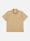 The Sand Rugby Jersey Oversized Vacation Polo is shown as a flat lay against a white background. The polo features an oversized fit, a one-piece collar, a short placket with no fastening, and a single patch pocket on the left chest. The fabric is a heavy-weight rugby jersey in a neutral sand color.