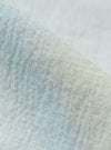 A close-up fabric swatch of the Green Seersucker Road Shirt highlights the material's signature puckered and wrinkled texture. The fabric features a fine, alternating weave in a solid green color, creating a lightweight and breathable appearance.