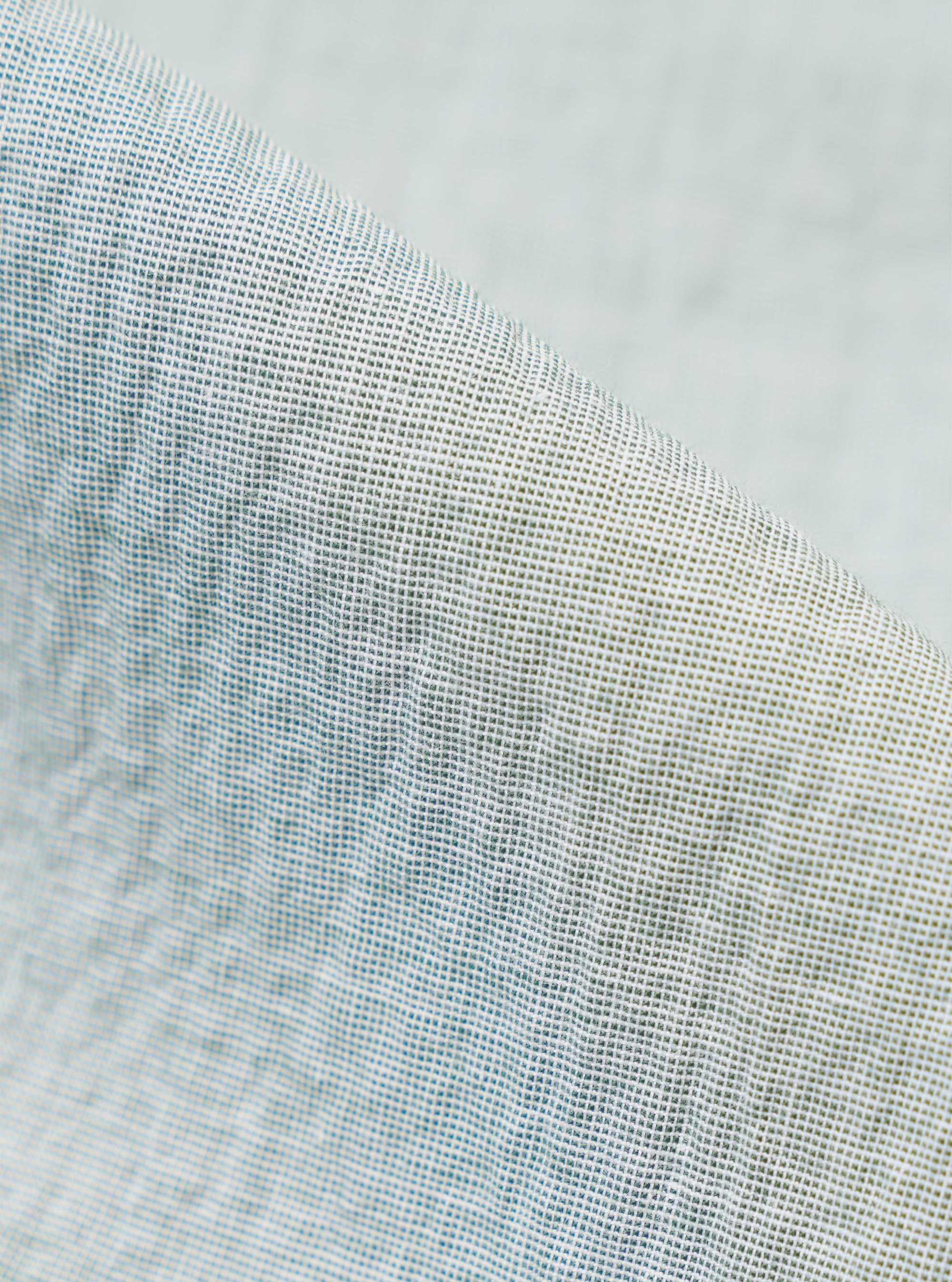 A close-up fabric swatch of the Green Seersucker Road Shirt highlights the material's signature puckered and wrinkled texture. The fabric features a fine, alternating weave in a solid green color, creating a lightweight and breathable appearance.