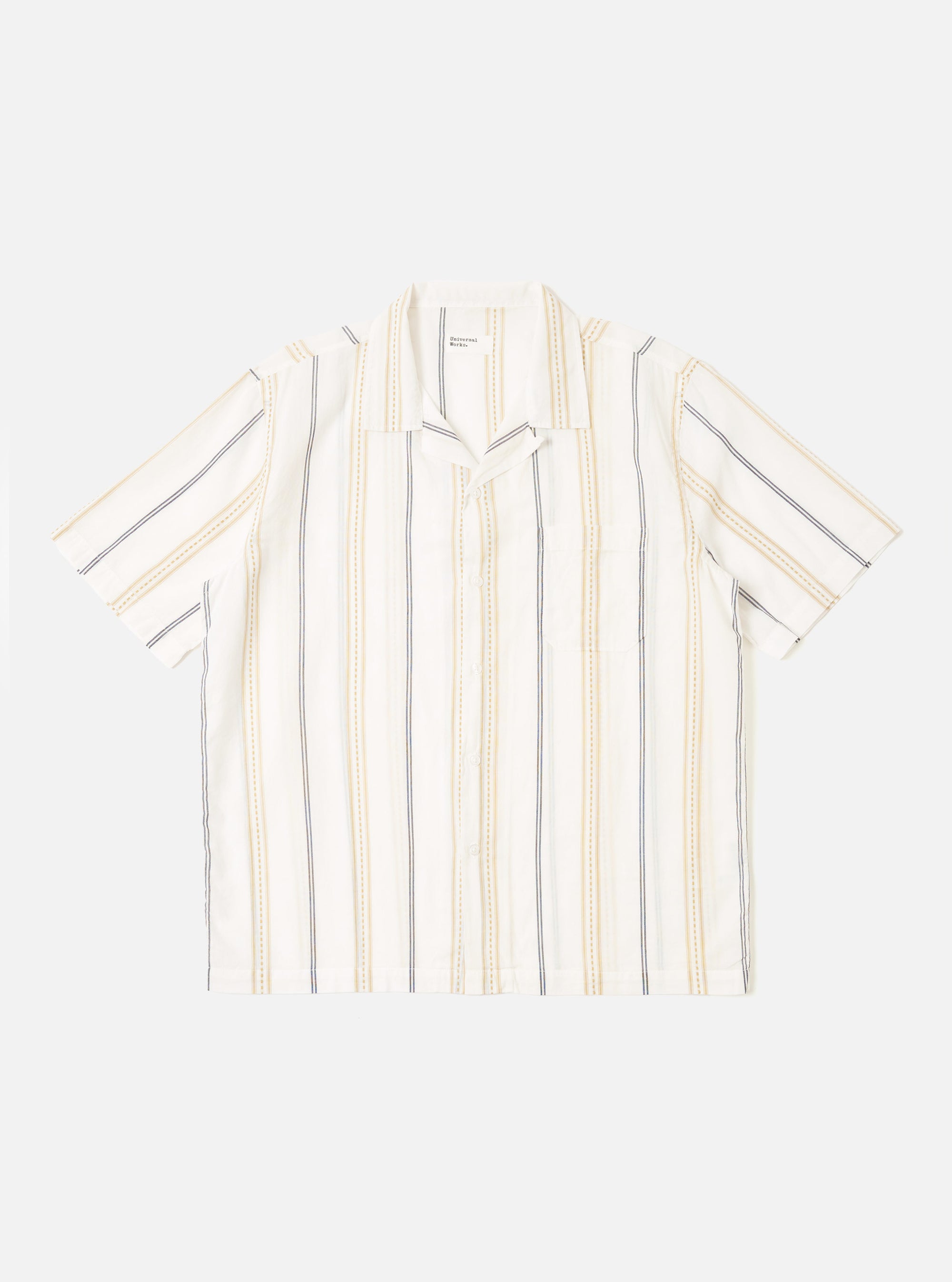 The Ecru/Navy/Sand Hendrix Stripe Road Shirt is shown as a flat lay against a plain white background. The shirt features a vertical stripe pattern in ecru, navy, and sand, a relaxed camp collar, and a central button-down front. It has short sleeves and a single patch pocket on the left chest.