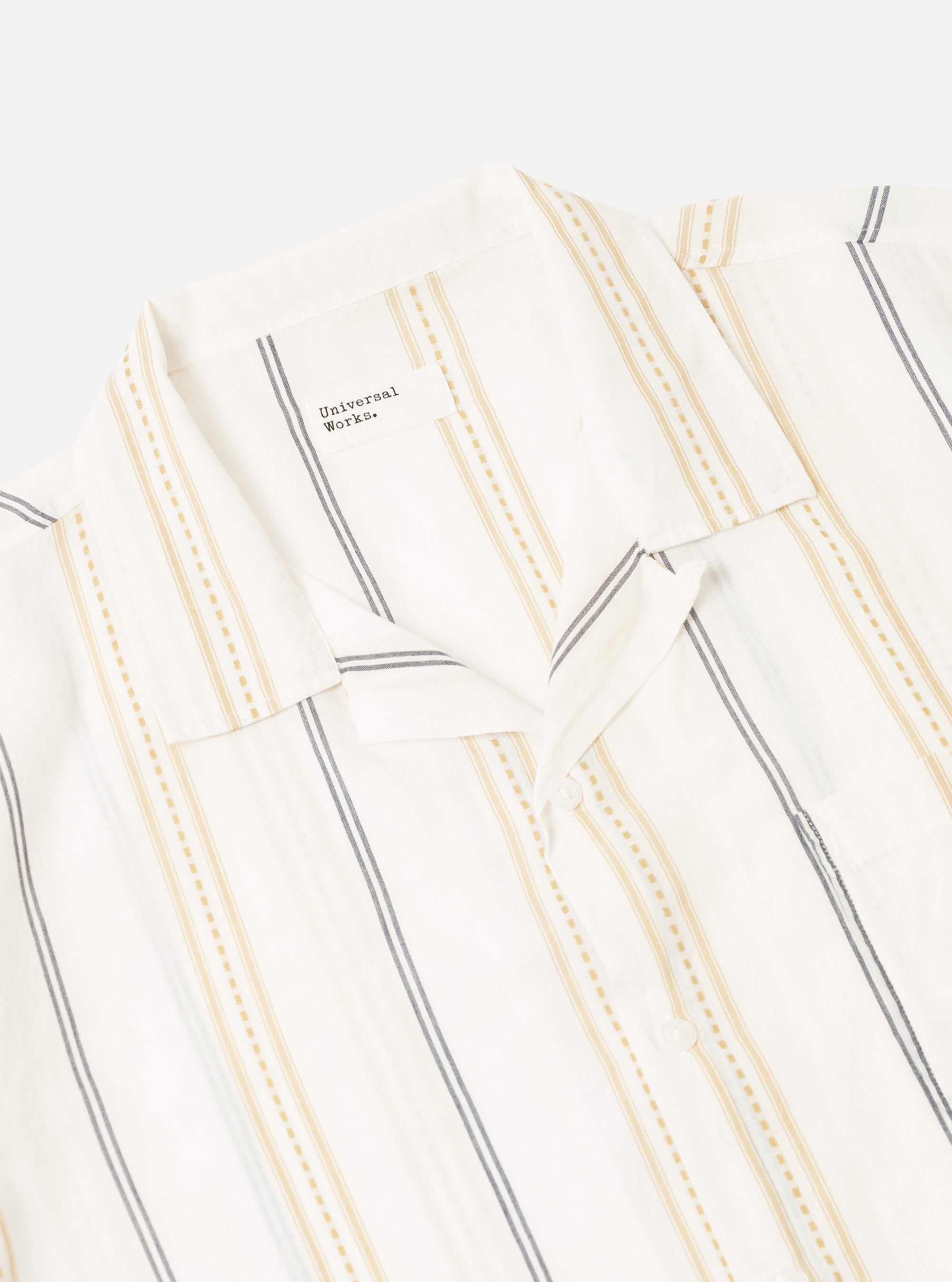The Ecru/Navy/Sand Hendrix Stripe Road Shirt is shown from the back as a flat lay against a plain white background. The image highlights the vertical stripe pattern in ecru, navy, and sand, as well as the straight hem and simple back yoke construction.