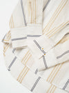 The Ecru/Navy/Sand Hendrix Stripe Square Pocket Shirt is shown as a flat lay against a plain white background. The shirt features a vertical stripe pattern in shades of ecru, navy, and sand. It is designed with a classic pointed collar, a central button-down front, and a prominent square patch pocket on the chest.