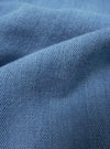 A close-up fabric swatch of the Washed Indigo Recycled Herringbone Attendant Shirt displays a deep indigo blue color with a distinct herringbone weave pattern. The texture of the recycled cotton material is clearly visible, highlighting the subtle tonal variations in the fabric.