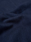 A close-up swatch of the Indigo Recycled Herringbone Kyoto Work Jacket highlights the deep indigo blue color and the distinct V-shaped herringbone weave of the fabric. The textured material fills the entire frame.