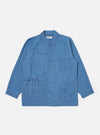 The Washed Indigo Recycled Herringbone Kyoto Work Jacket is shown as a flat lay against a white background. The jacket features a wrap-style front with fabric ties, two large patch pockets at the waist, and a single patch pocket on the left chest. The indigo-washed cotton fabric displays a distinct herringbone weave pattern.