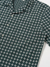 The Green/White Rhodes 8 Cotton Road Shirt is shown from the back as a flat lay against a plain white background. The image highlights the short-sleeve construction, straight hem, and the vertical striped pattern in green and white. The one-piece collar and the smooth texture of the cotton fabric are visible.