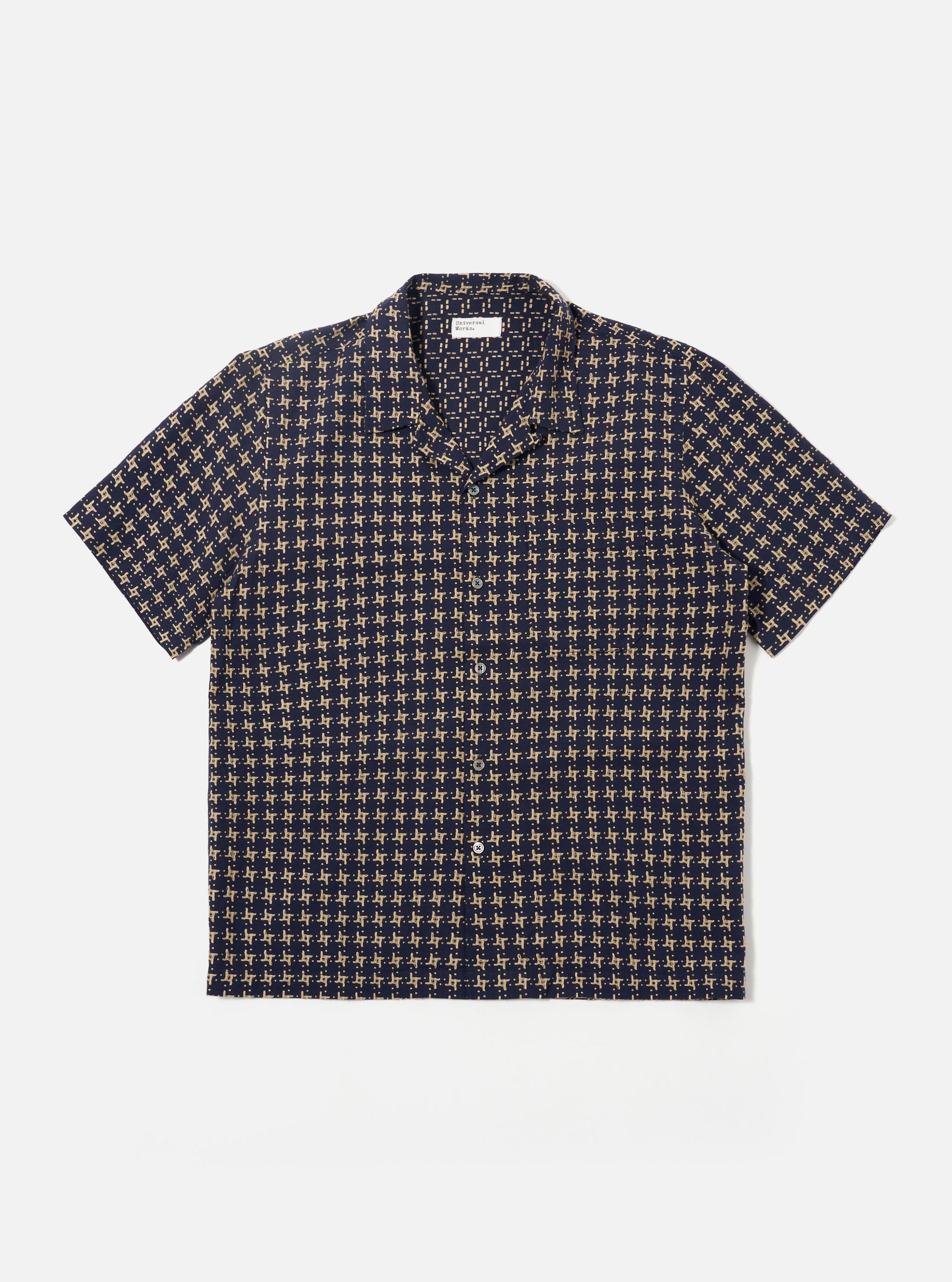 The Navy/Sand Rhodes 8 Cotton Road Shirt is shown as a flat lay against a white background. The shirt features a relaxed camp collar, a central button-down front, and short sleeves. The fabric is decorated with a patterned design in navy and sand colors.