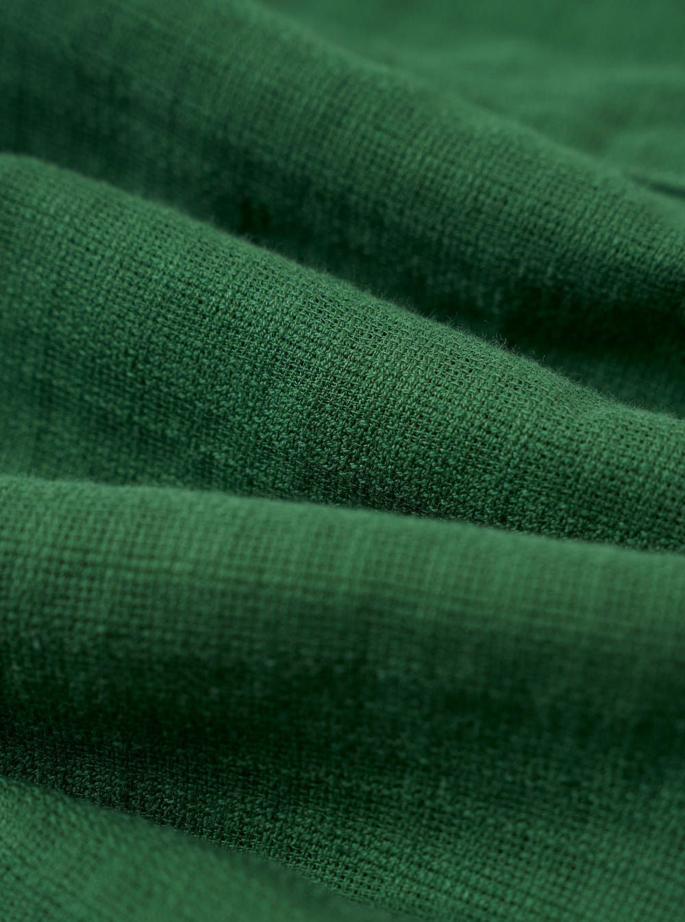A close-up fabric swatch of the Green Letts Cotton Road Shirt highlights the olive green color and the fine, textured weave of the cotton material.