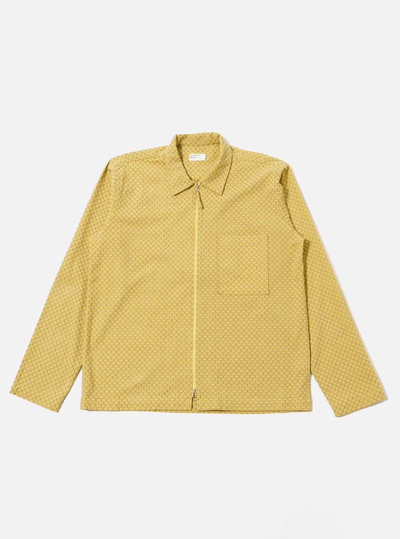 The Yellow Mykonos Cotton Zip Shirt is shown as a flat lay against a white background. The shirt features a full-length central silver zipper, a classic structured collar, and two large patch pockets at the waist. The cotton fabric is a vibrant yellow with a subtle, fine-textured weave.
