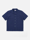 The Blue Maui Cotton Road Shirt is shown as a flat lay against a white background. The short-sleeve shirt features a vertical blue and white stripe pattern, a one-piece camp collar with a loop-button closure at the neck, and a single large patch pocket on the left chest. It has a straight hem and