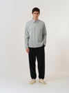 The Green Seersucker Square Pocket Shirt is displayed as a flat lay against a plain white background. The shirt features a button-down front, a structured pointed collar, and a prominent square patch pocket on the left chest. The solid green fabric has a distinct puckered seersucker texture throughout.