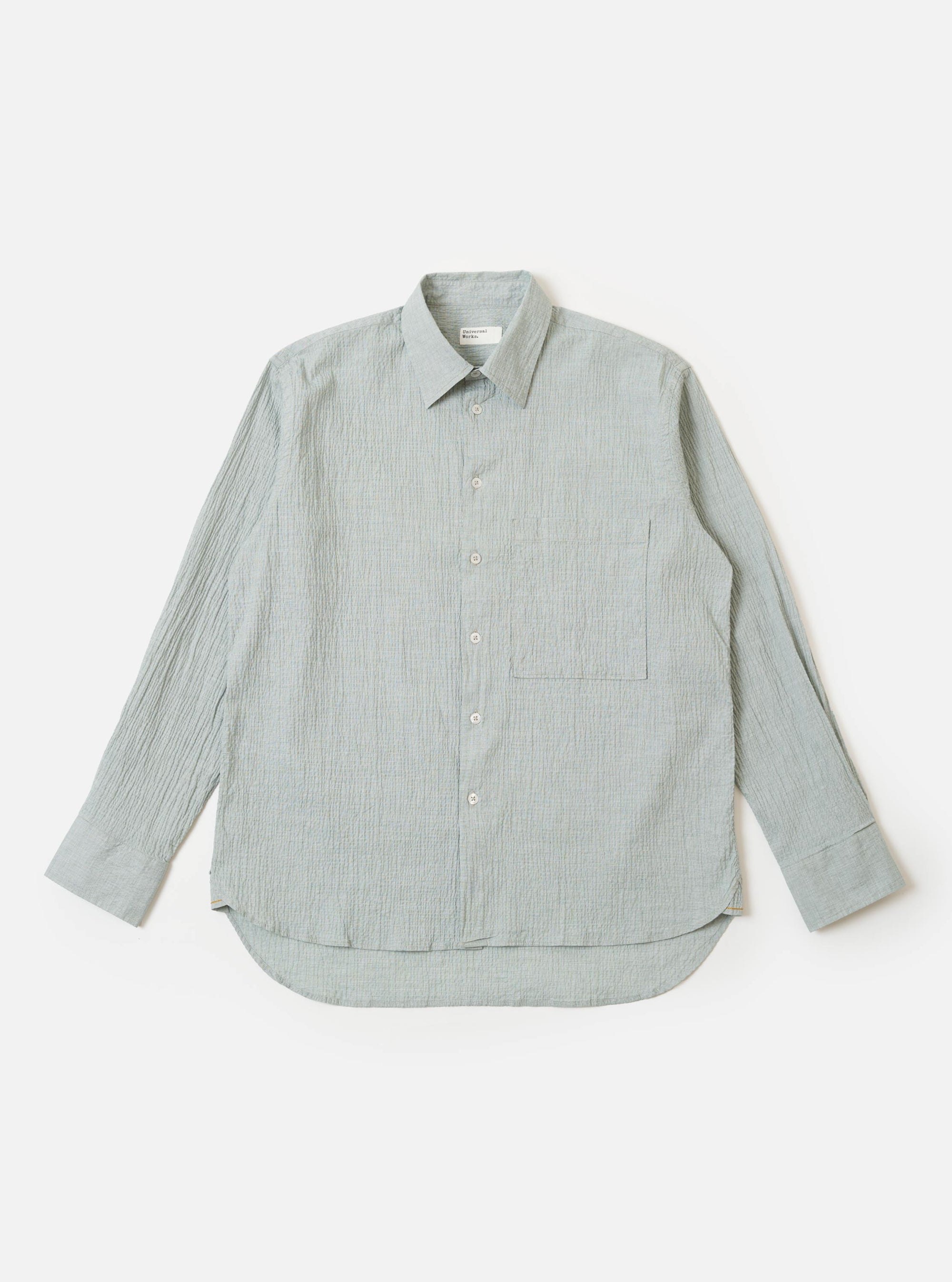 The Green Seersucker Square Pocket Shirt is shown as a flat lay against a white background. The shirt features a button-down front, a classic collar, and two prominent square patch pockets at the chest. The fabric has a distinct puckered seersucker texture in a solid green color.