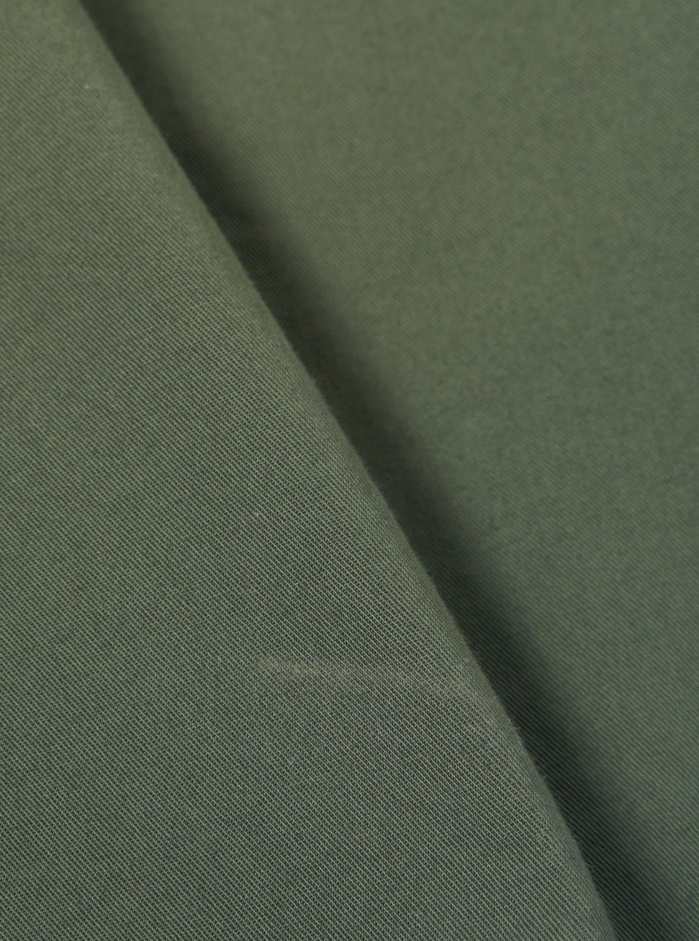 A close-up swatch image of the Olive Kelly Cotton Simple Short fabric highlights the olive green color and the subtle, woven texture of the kelly cotton material. The fabric fills the frame, providing a detailed view of the garment's color and construction.