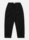 The Black Kelly Cotton Judo Pant is shown as a flat lay against a plain white background. The trousers feature a straight, wide-leg silhouette with an elasticated waistband and a visible tonal drawstring. Two side pockets are prominent at the hips. The fabric appears sturdy with a smooth finish.