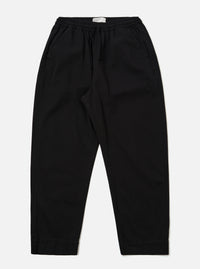 The Black Kelly Cotton Judo Pant is shown as a flat lay against a plain white background. The trousers feature a straight, wide-leg silhouette with an elasticated waistband and a visible tonal drawstring. Two side pockets are prominent at the hips. The fabric appears sturdy with a smooth finish.