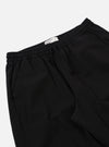 The Black Kelly Cotton Judo Pant is shown from a rear three-quarter angle as a flat lay against a white background. This view highlights the simple, straight-leg construction and the single rear patch pocket on the right side. The elasticated waistband and the absence of a traditional fly are clearly visible.