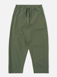The Olive Kelly Cotton Judo Pant is shown as a flat lay against a plain white background. The trousers feature a wide, straight-leg silhouette, an elasticated waistband with an external drawstring, and two large patch pockets on the front. The fabric is a solid olive green cotton with a visible textured weave.