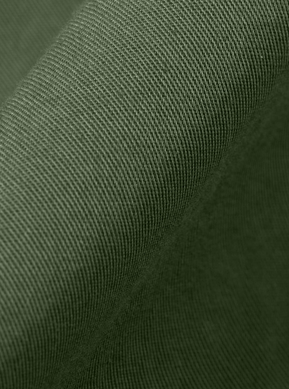 A close-up fabric swatch of the Olive Kelly Cotton Glider Jacket is shown, highlighting the smooth texture and solid olive green color of the cotton material.