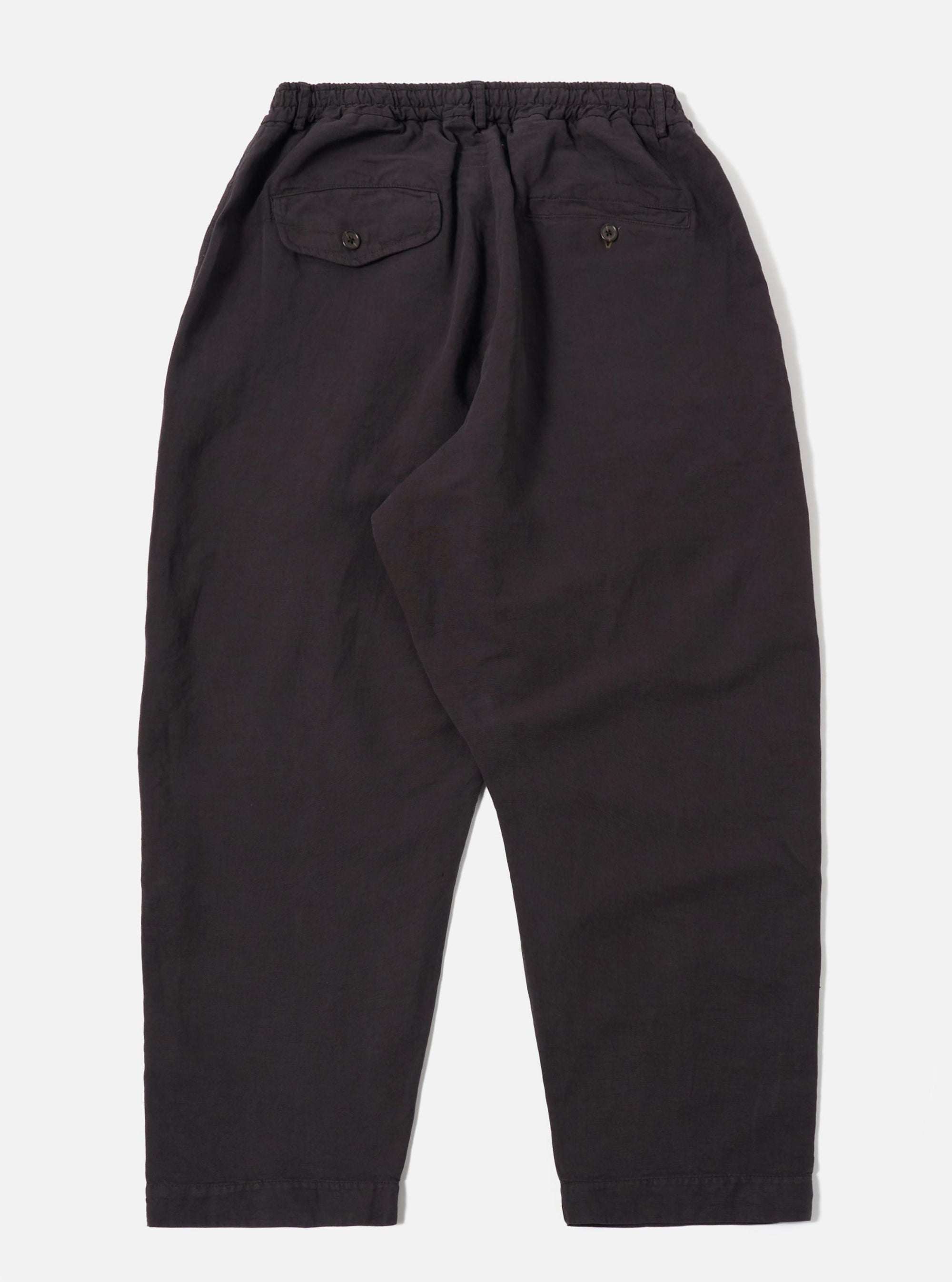 The Licorice Lyo Linen Mix Oxford Pant is shown from the rear as a flat lay against a plain white background. The image highlights the dark brown fabric and features a visible elasticated waistband with a drawstring and two rear patch pockets. The trousers have a loose, wide-leg fit.