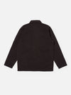 The Licorice Lyo Linen Mix Coverall Jacket is shown from the back as a flat lay against a plain white background. The image highlights the simple, clean construction of the garment's rear, the straight hem, and the dark brown textured fabric. A small pen pocket is visible on the upper left sleeve.