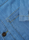 The Washed Indigo 8oz Slub Denim Field Jacket is shown from a rear angle as a flat lay against a plain white background. The image highlights the clean construction of the back panel, the straight hem, and the textured appearance of the washed indigo slub denim fabric.