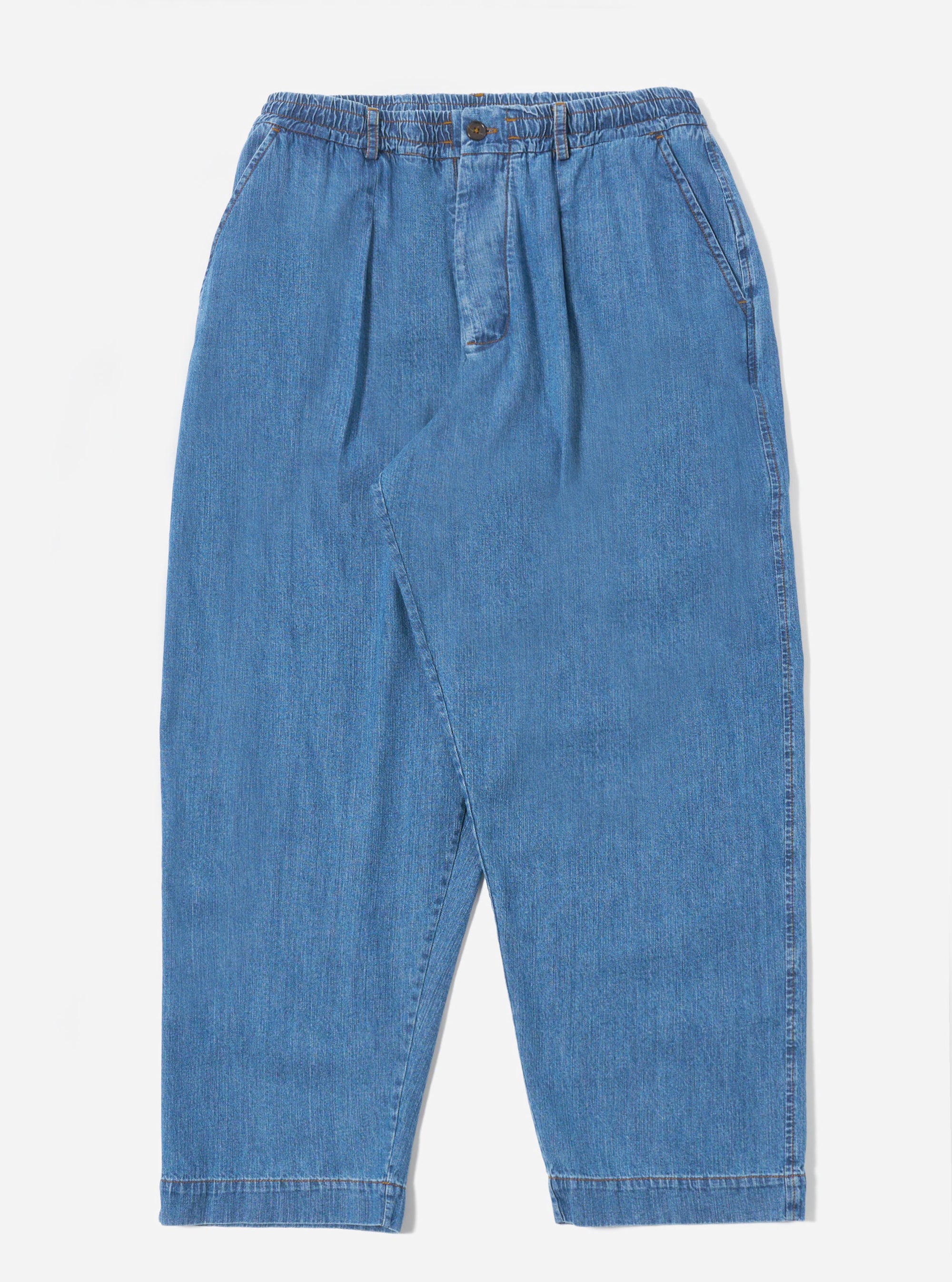 The Washed Indigo 8oz Slub Denim Oxford Pant is shown as a flat lay against a white background. The trousers feature a wide-leg fit, a drawstring elasticated waistband, and a single pleat on each leg. The 8oz slub denim fabric has a visible textured, light blue washed indigo finish.
