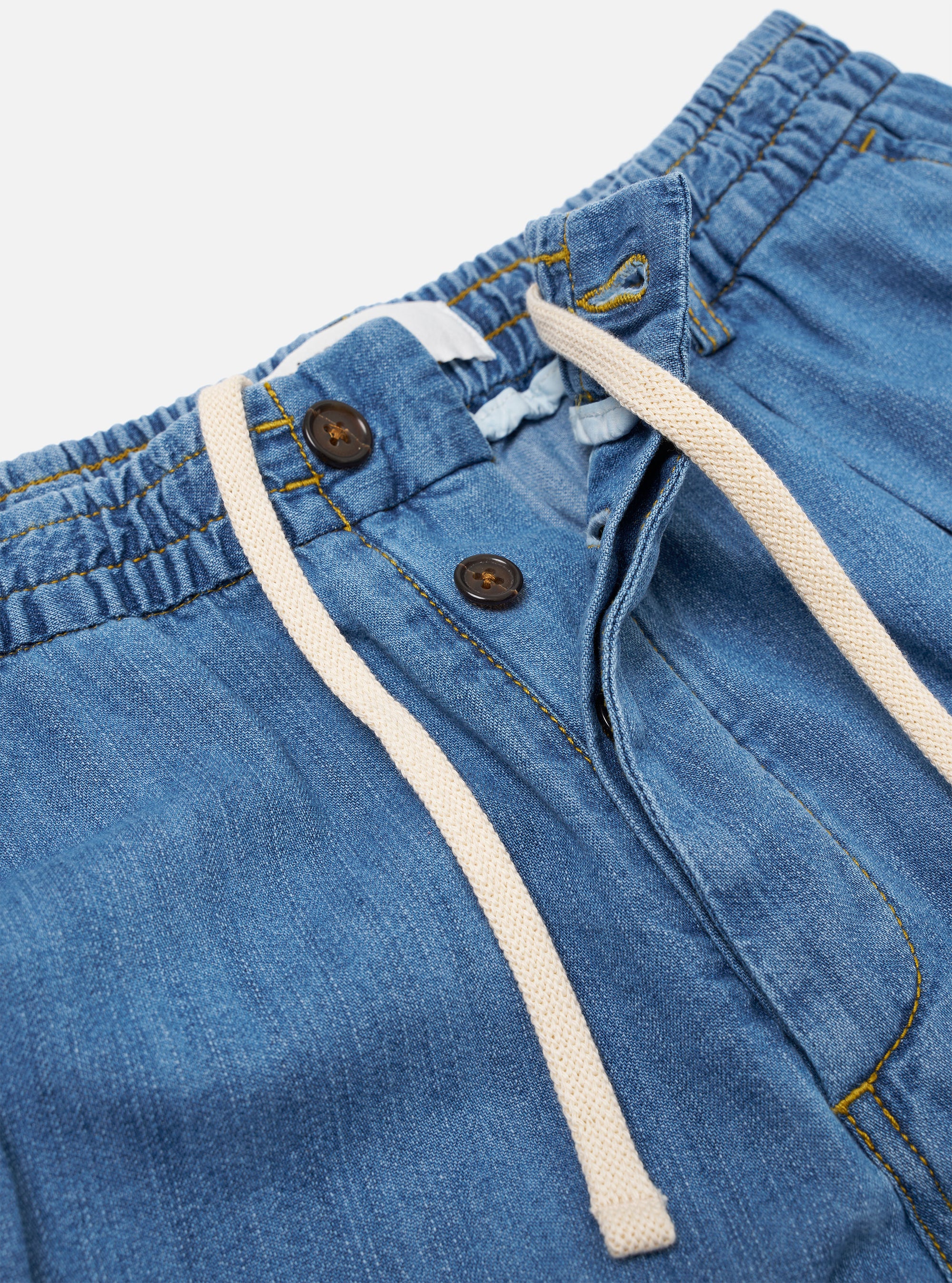 The Washed Indigo 8oz Slub Denim Oxford Pant is shown from the back as a flat lay against a plain white background. The trousers feature a wide-leg cut, an elasticated waistband, and a single rear patch pocket on the right side. The washed indigo denim fabric displays a distinct slubby texture.