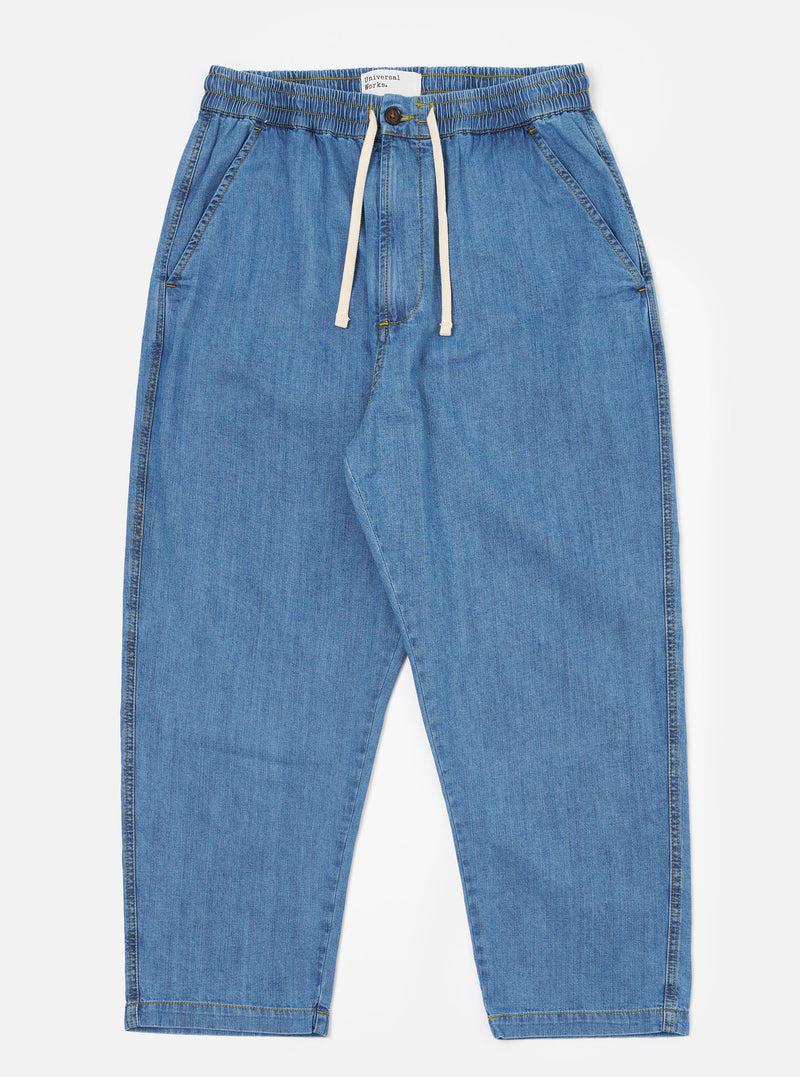 The Washed Indigo 8oz Slub Denim Hi Water Trouser is shown as a flat lay against a plain white background. The trousers feature an adjustable drawstring waist, two slanted front pockets, and a slightly cropped leg length. The 8oz slub denim fabric has a washed indigo finish with a visible textured appearance.