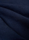 A close-up fabric swatch of the Indigo Recycled Herringbone Pleated Track Short displays the blue and white herringbone weave pattern.