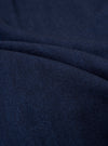A close-up swatch image of the Indigo Recycled Herringbone Pleated Track Pant fabric highlights the intricate V-shaped herringbone weave. The textile features a deep indigo blue color with a textured, three-dimensional appearance.