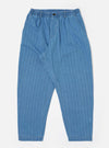 The Washed Indigo Recycled Herringbone Pleated Track Pant is shown as a flat lay against a white background. The trousers feature an elasticated waistband with an external drawstring, a single pleat at the front, and a loose, tapered leg. Two side pockets are visible, and the fabric displays a distinct herringbone texture in a washed indigo blue.