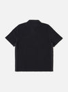 The Black Light Weight Terry Newlyn Polo is shown from the back as a flat lay against a plain white background. The image highlights the clean lines of the rear panel, the back of the collar, and the short sleeves. The black fabric features a visible, soft-textured light weight terry loop finish.