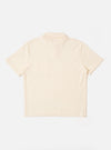 The Ecru Light Weight Terry Newlyn Polo is shown from the back as a flat lay against a plain white background. The image highlights the clean construction of the rear panel, the short sleeves, and the ribbed texture of the light weight terry fabric in a solid ecru color.