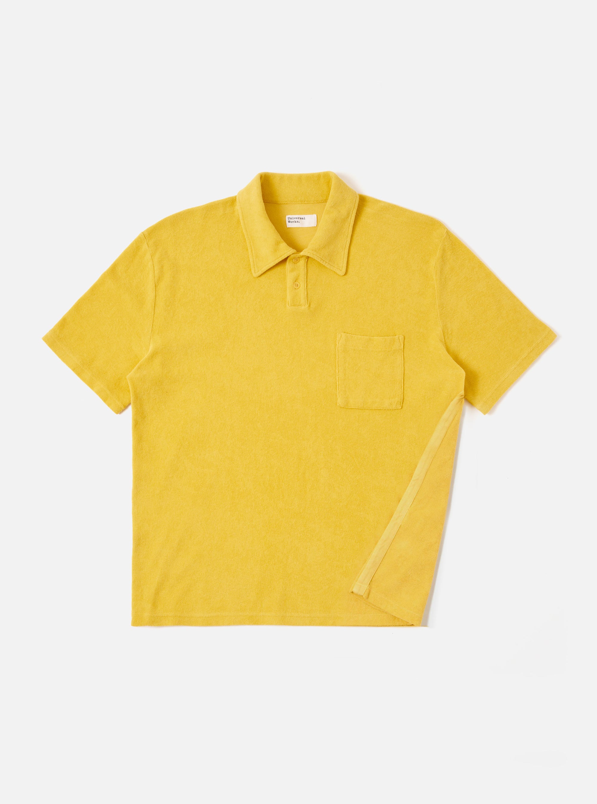 The Yellow Light Weight Terry Newlyn Polo is shown as a flat lay against a plain white background. The shirt features a classic collar, a three-button placket, and short sleeves. The garment is made from a soft, textured yellow terry cotton fabric.
