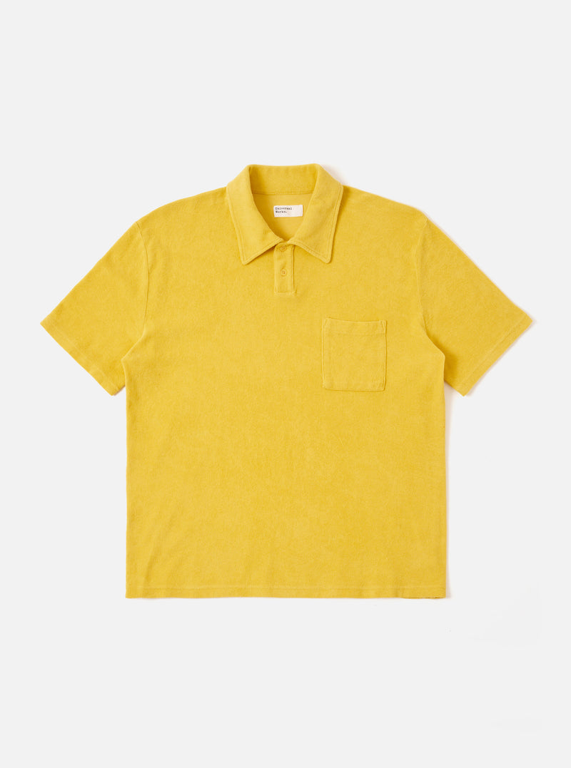 The Yellow Light Weight Terry Newlyn Polo is shown as a flat lay against a white background. The polo features a classic collar, a three-button placket, and a single chest patch pocket. The garment is made from a yellow textured terry cloth fabric with short sleeves and a straight hem.