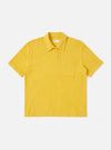 The Yellow Light Weight Terry Newlyn Polo is shown as a flat lay against a white background. The polo features a classic collar, a three-button placket, and a single chest patch pocket. The garment is made from a yellow textured terry cloth fabric with short sleeves and a straight hem.