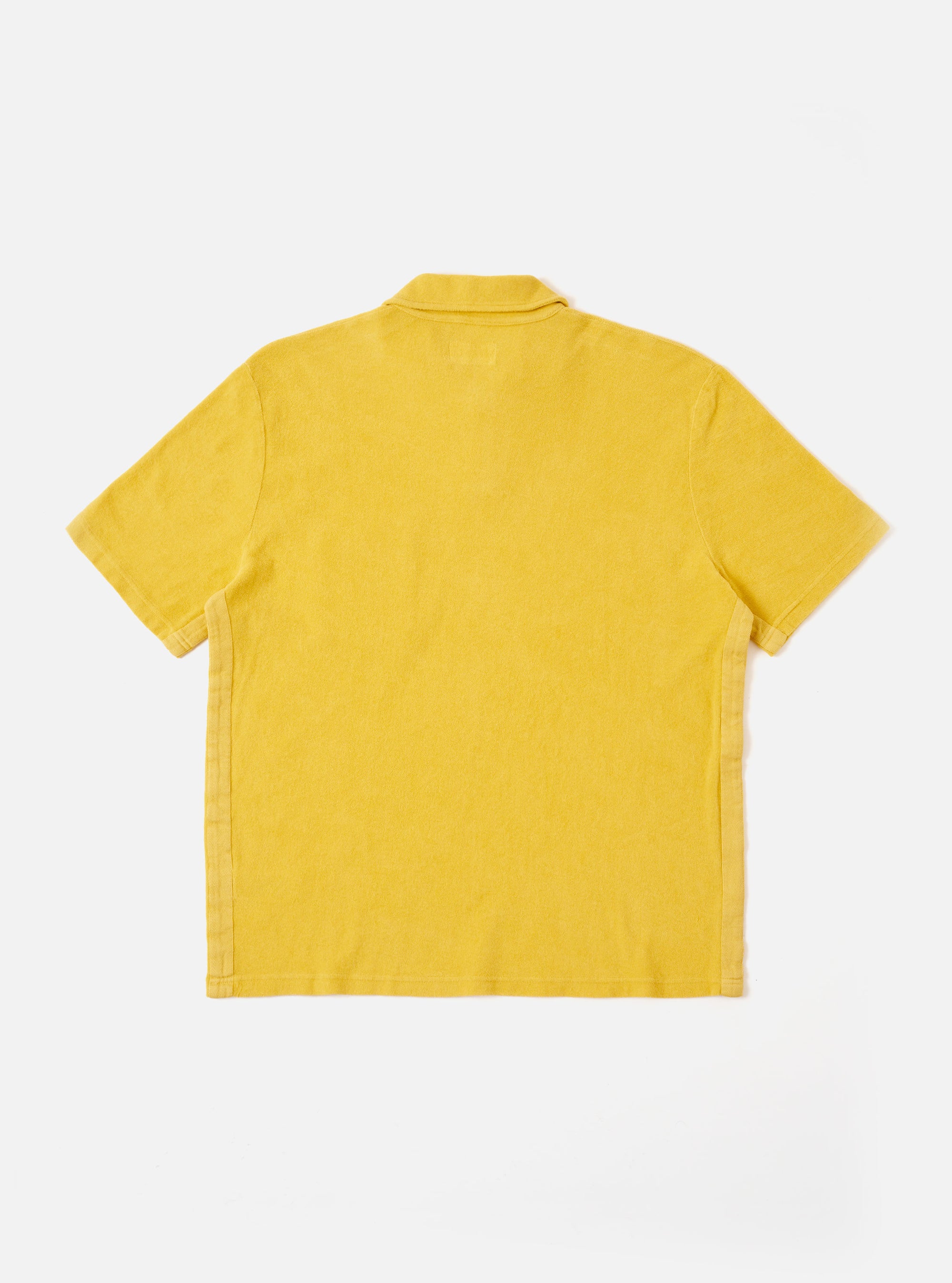 The Yellow Light Weight Terry Newlyn Polo is shown from the back as a flat lay against a plain white background. The image highlights the soft, looped texture of the yellow terry fabric, the short sleeves, and the straight hem.