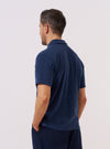 A model is wearing the Navy Light Weight Terry Newlyn Polo against a plain white background, shown from the back. The polo features a relaxed fit, a simple one-piece collar, and a straight hem with side splits. The navy blue fabric has the soft, textured appearance of lightweight terry cotton. No mannequin is present in the image.