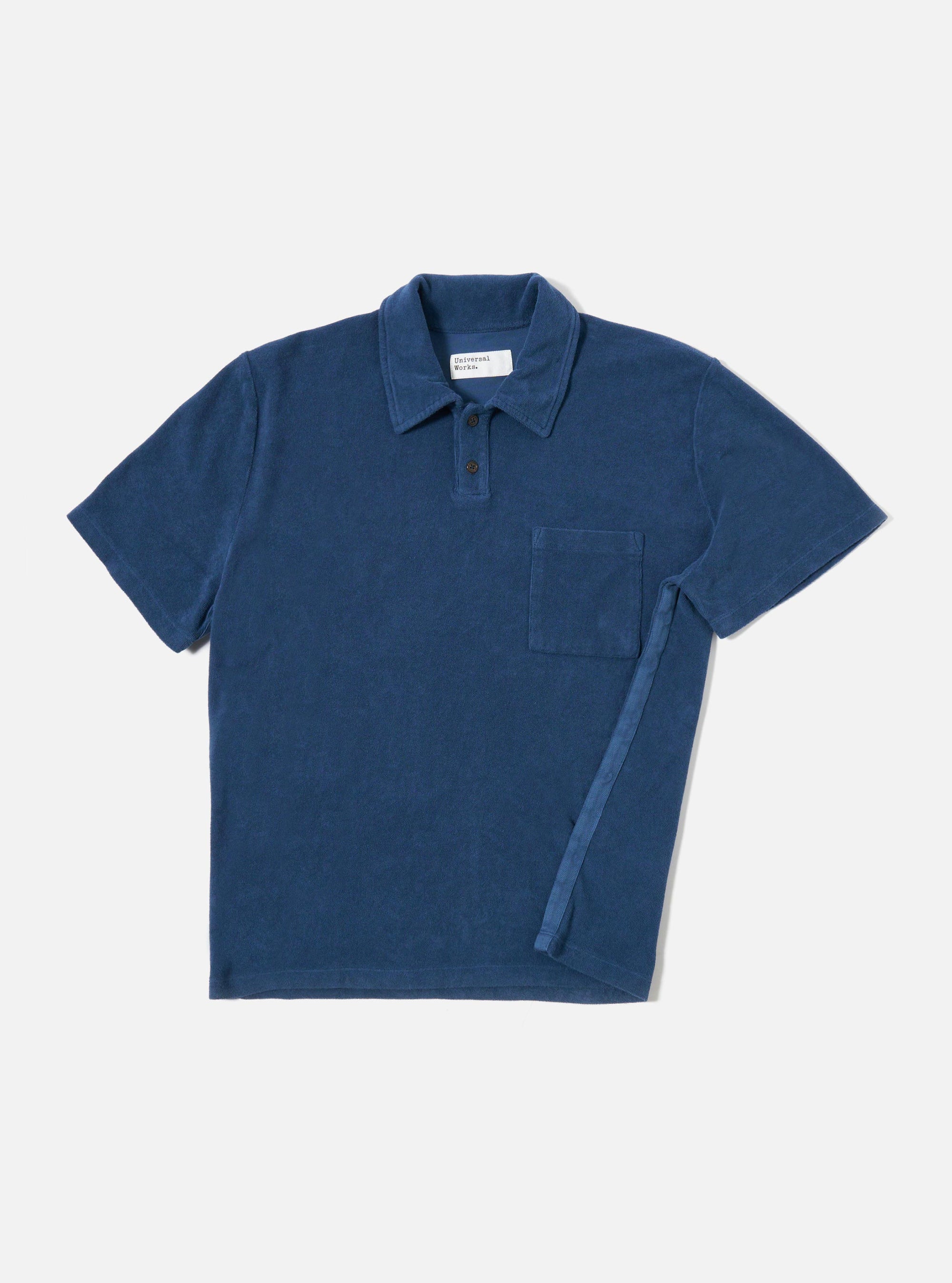 The Navy Light Weight Terry Newlyn Polo is shown as a flat lay against a white background. The polo features a simple one-piece collar, a large patch pocket on the left chest, and short sleeves. The fabric has a fine terry texture in a deep navy blue.