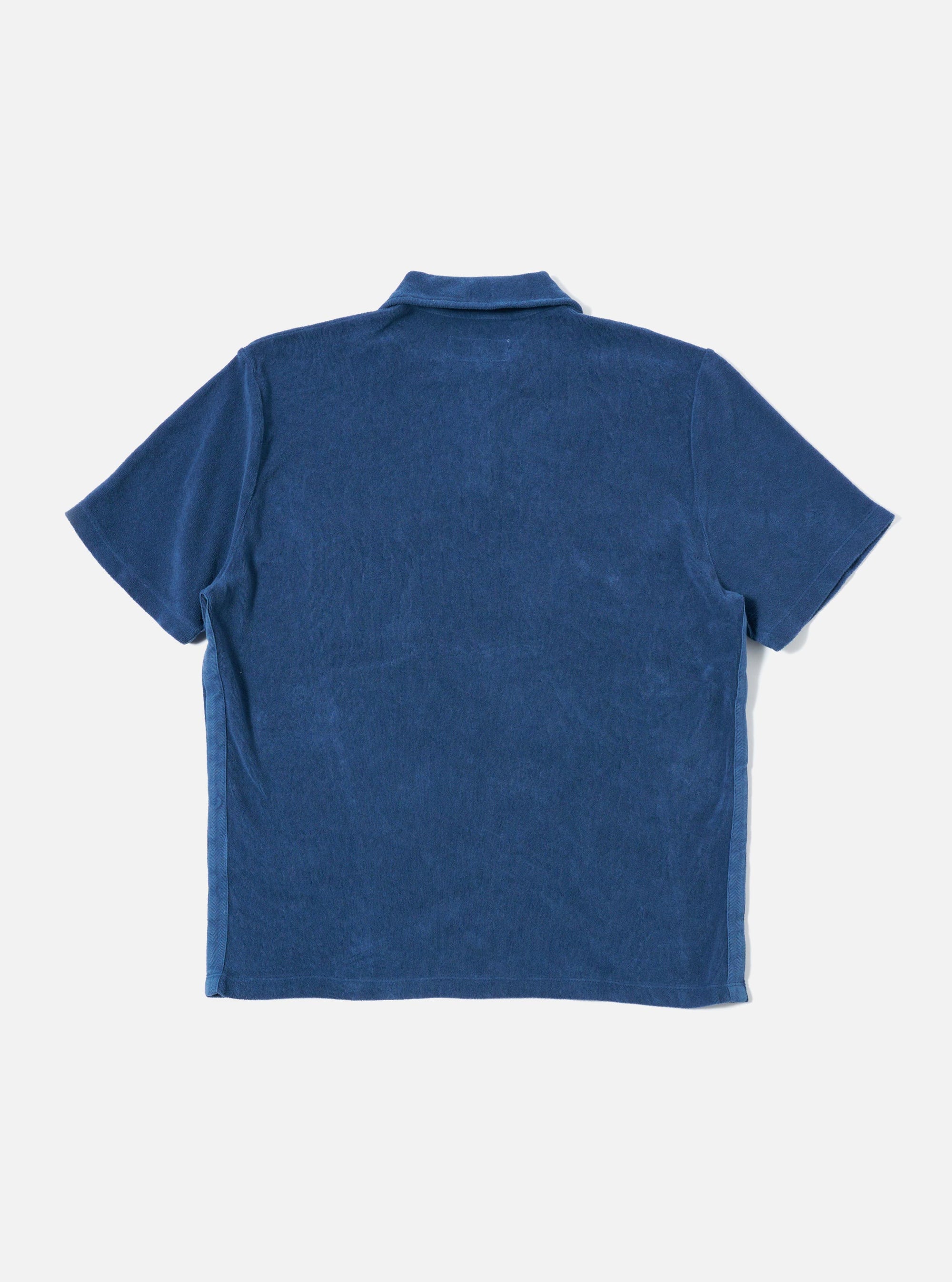 The Navy Light Weight Terry Newlyn Polo is shown from the back as a flat lay against a plain white background. The image highlights the textured navy terry fabric, the back of the collar, and the clean hemline of the garment.