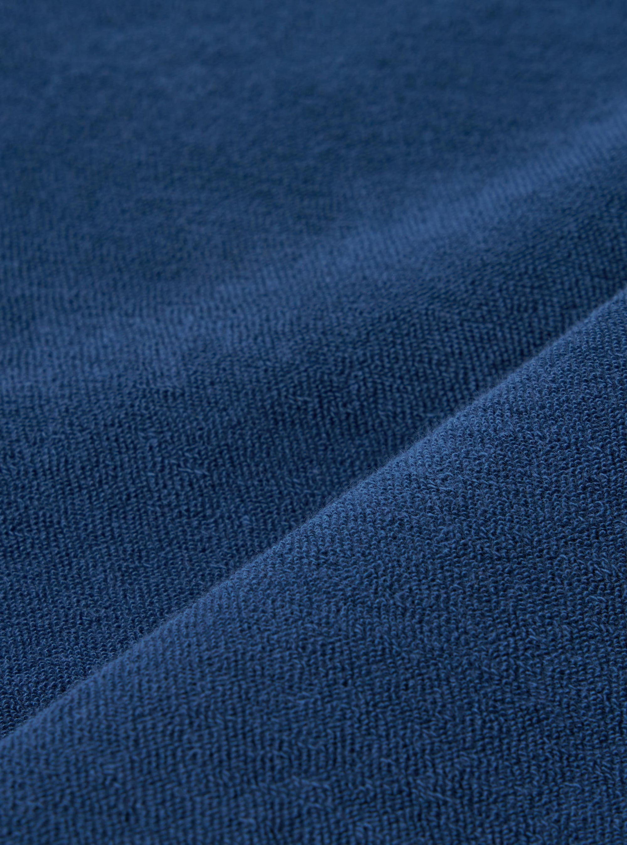 A close-up swatch image of the Navy Light Weight Terry Newlyn Polo fabric displays a deep navy blue color with a soft, looped terry cloth texture. The material is shown as a detailed textile sample against a neutral background.