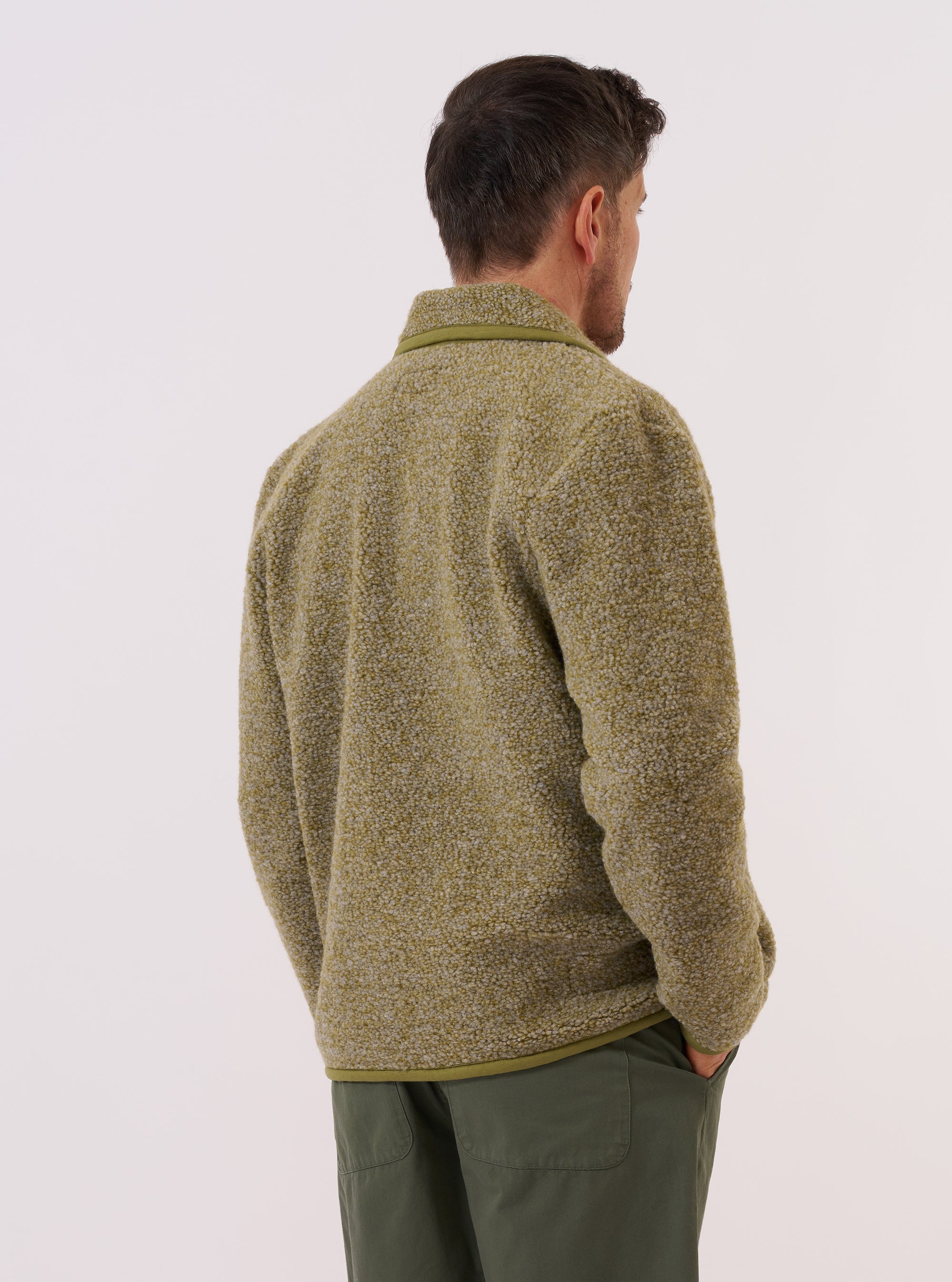 A model is wearing the Light Olive Alvar Fleece Lancaster Jacket, shown from the back against a plain white background. The jacket is made from a textured light olive green fleece fabric and features a rounded shawl collar, a relaxed fit, and a straight hem. No mannequin is present in the image.