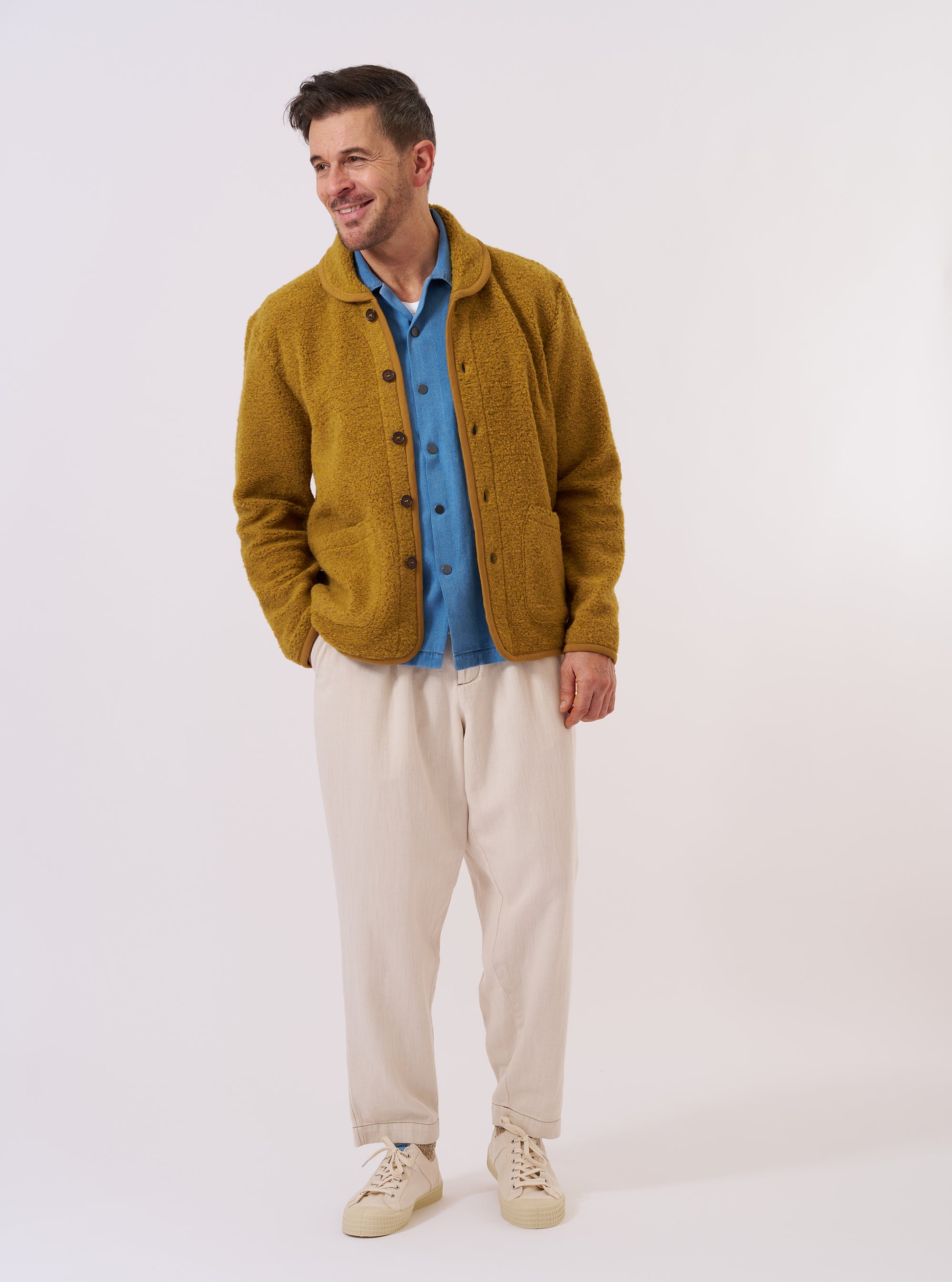 The Yellow Alvar Fleece Lancaster Jacket is shown as a flat lay against a plain white background. This fleece jacket features a curved shawl collar, a six-button front closure, and two large patch pockets at the waist. The garment is made from a textured yellow alvar fleece with tonal trim along the edges.