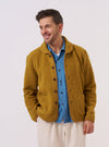 A model wears the Yellow Alvar Fleece Lancaster Jacket while standing against a plain white background. The jacket features a rounded shawl collar, a six-button front closure, and two large patch pockets at the waist. The vibrant yellow fabric has a soft, textured fleece appearance.
