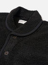 The Black Alvar Fleece Lancaster Jacket is shown as a flat lay against a plain white background. The jacket is crafted from a textured black fleece fabric and features a rounded shawl collar, a central button-down front, and large patch pockets at the waist.