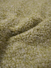 A close-up fabric swatch of the Light Olive Alvar Fleece Lancaster Jacket is displayed, highlighting the thick and curly texture of the light olive green fleece material. No background, model, or mannequin is present in the image.