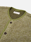 The Light Olive Alvar Fleece Lancaster Gilet is shown as a flat lay against a plain white background. The gilet is crafted from a textured, looped-weave fleece in a light olive green color. It features a five-button front closure, a curved shawl-style collar, and two large patch pockets at the waist. Tonal jersey binding finishes the edges of the garment.