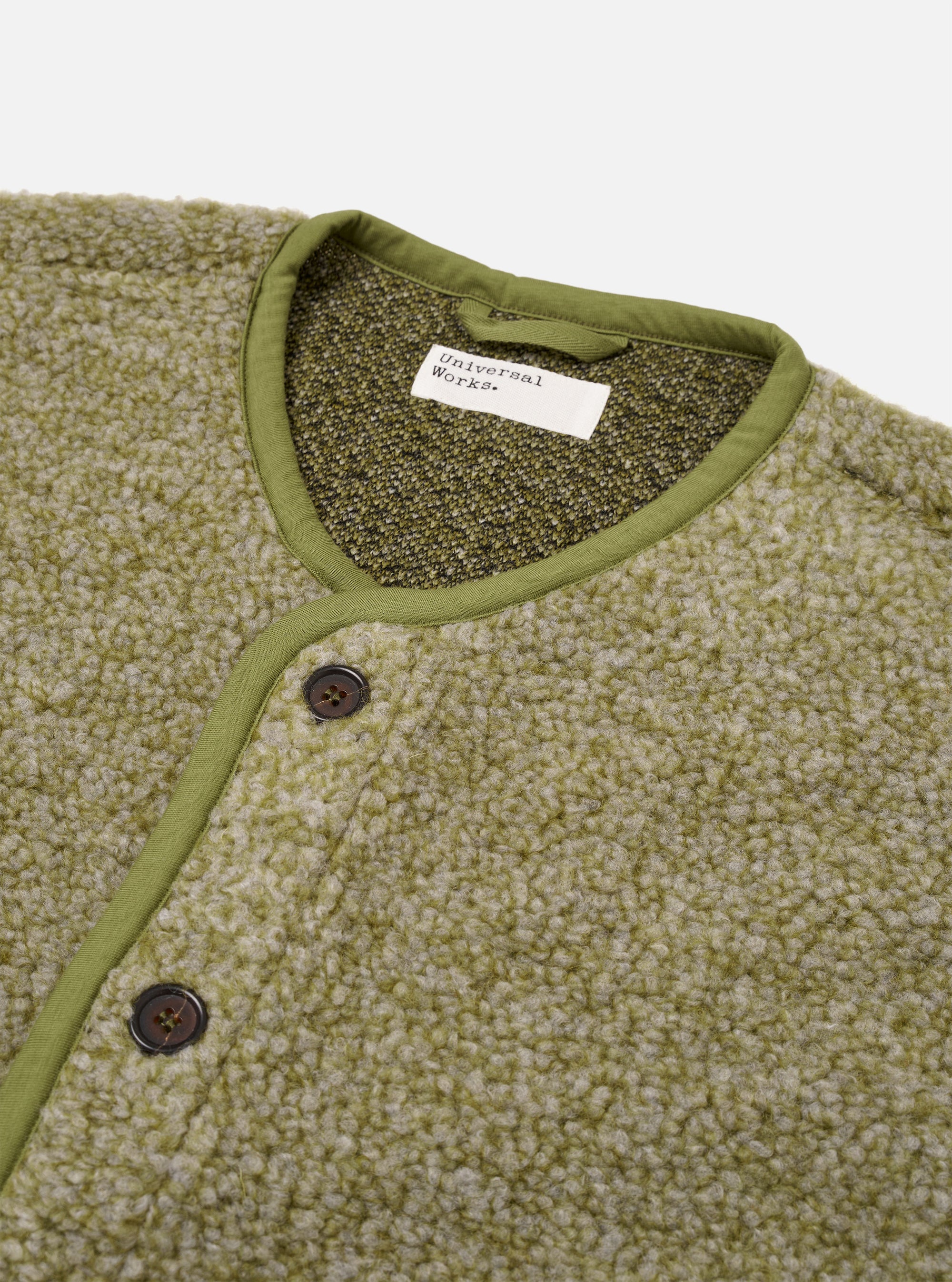 The Light Olive Alvar Fleece Lancaster Gilet is shown as a flat lay against a plain white background. The gilet is crafted from a textured, looped-weave fleece in a light olive green color. It features a five-button front closure, a curved shawl-style collar, and two large patch pockets at the waist. Tonal jersey binding finishes the edges of the garment.
