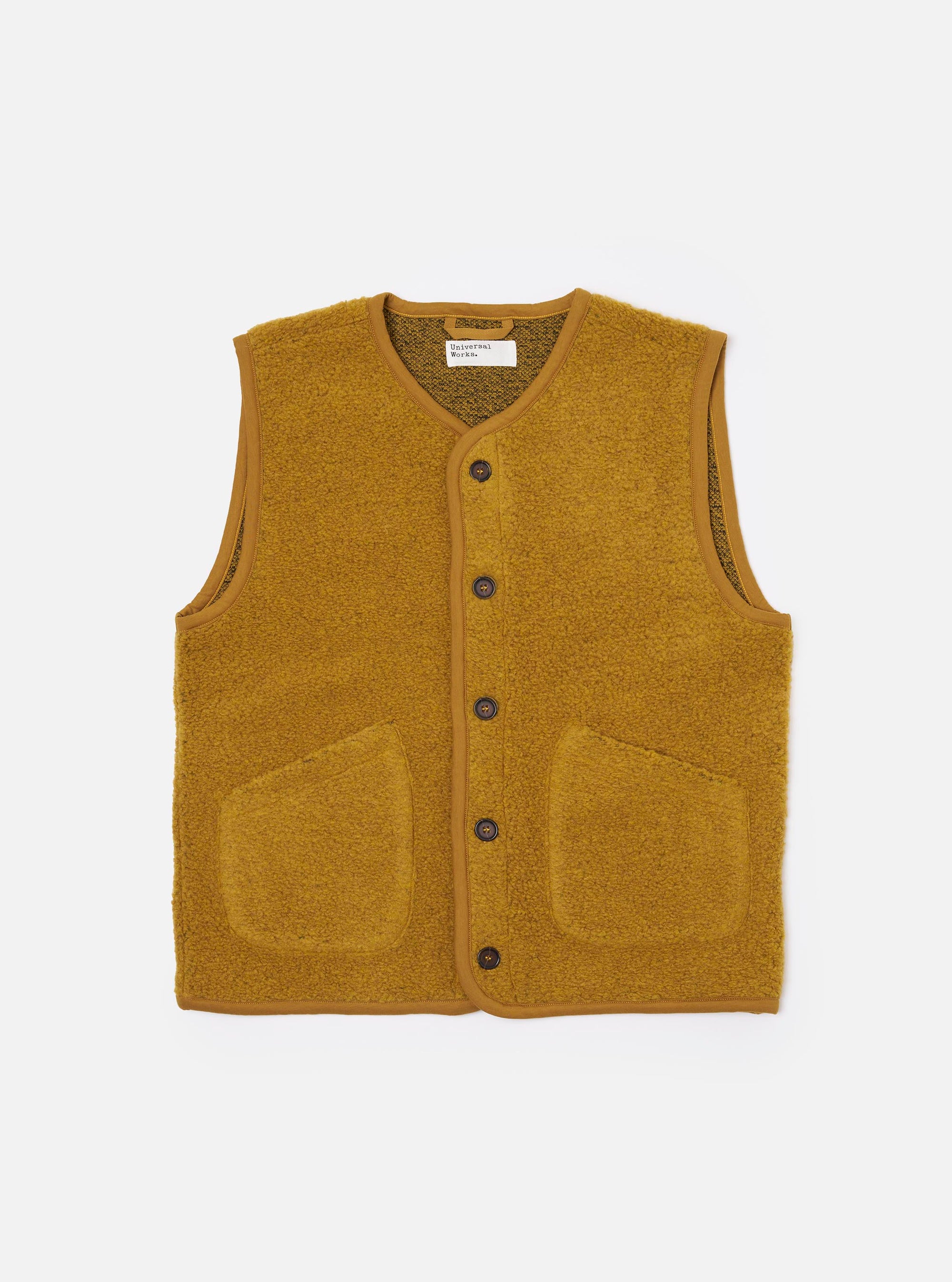 The Yellow Alvar Fleece Lancaster Gilet is presented as a flat lay against a plain white background. The gilet features a deep V-neckline, a five-button front closure, and two large patch pockets at the waist. The fabric has a distinct, richly textured looped weave in a vibrant yellow-ochre shade with simple tonal binding along the edges.