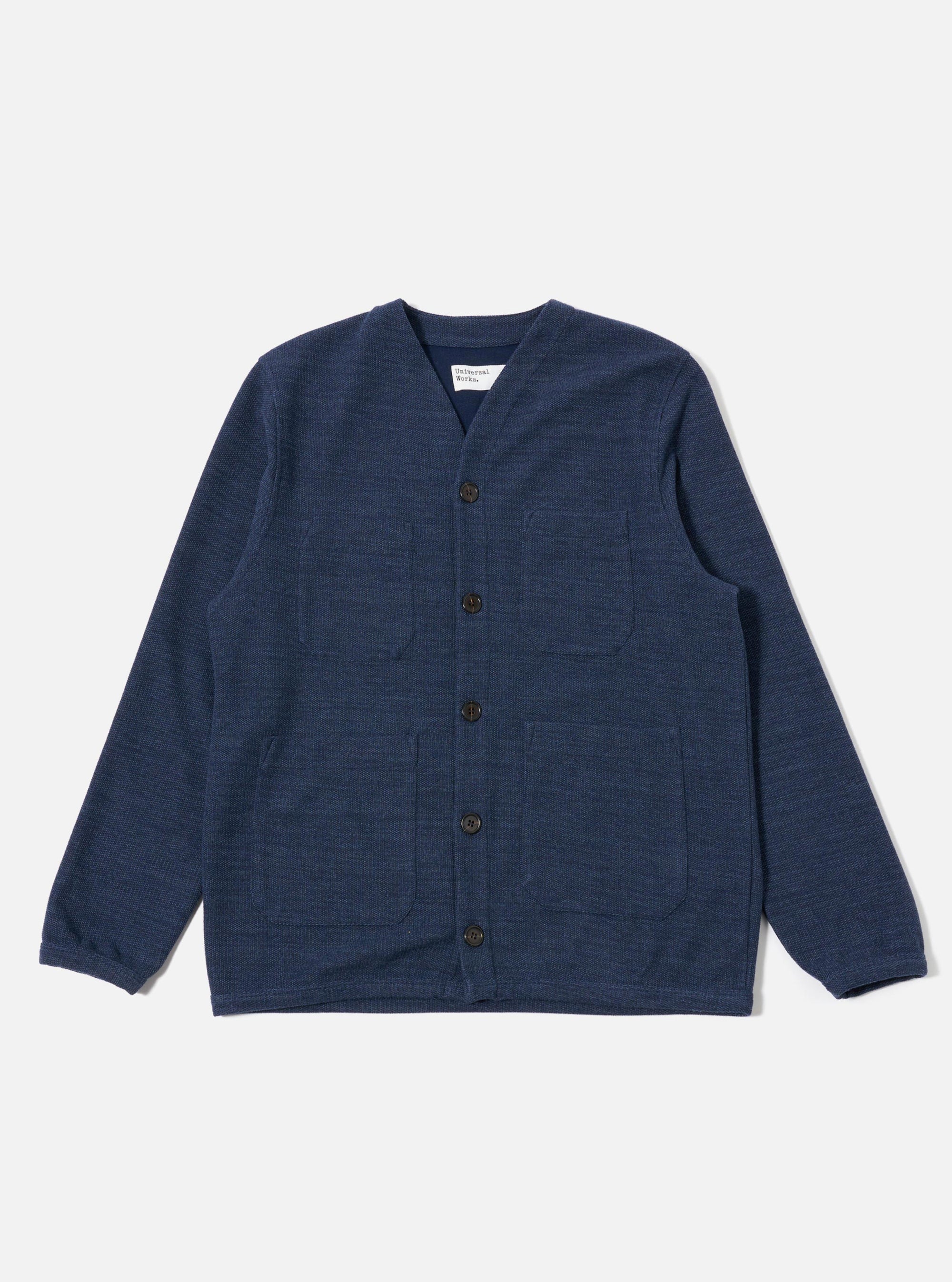 The Navy Maiorca Jersey Cardigan is shown as a flat lay against a white background. The cardigan features a curved v-neck collar, a five-button front closure, one single patch chest pocket, and two large patch hand pockets. It is finished with cotton rib-bound cuffs and a matching rib-bound hem. The fabric has a distinct textured basket-weave pattern in a deep navy indigo look.